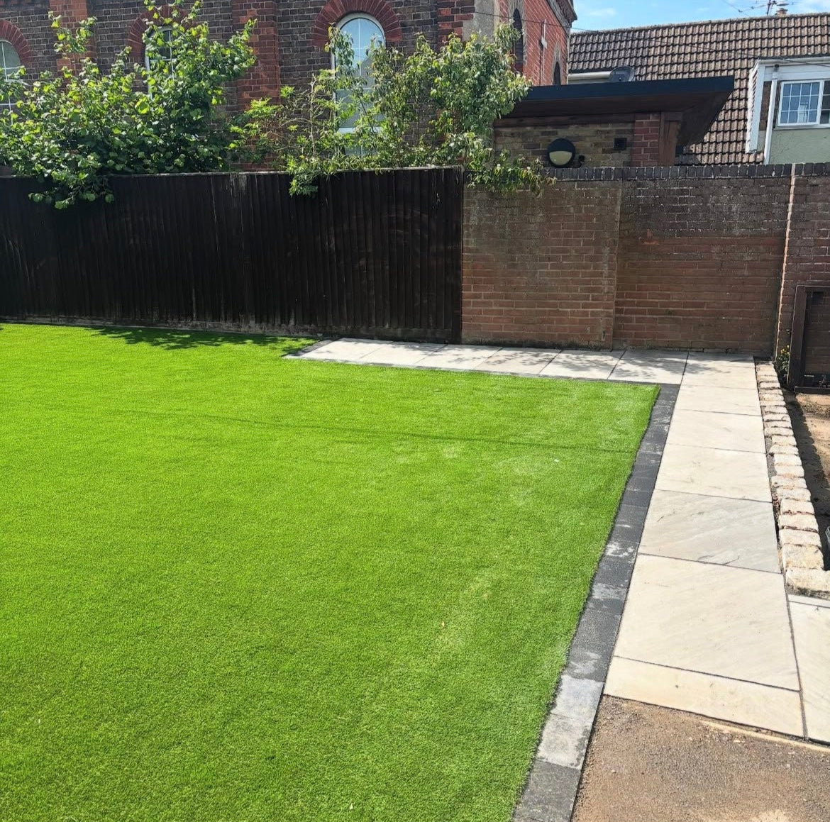 Back garden in Chinnor with 38mm softy artificial turf and patio slabs.