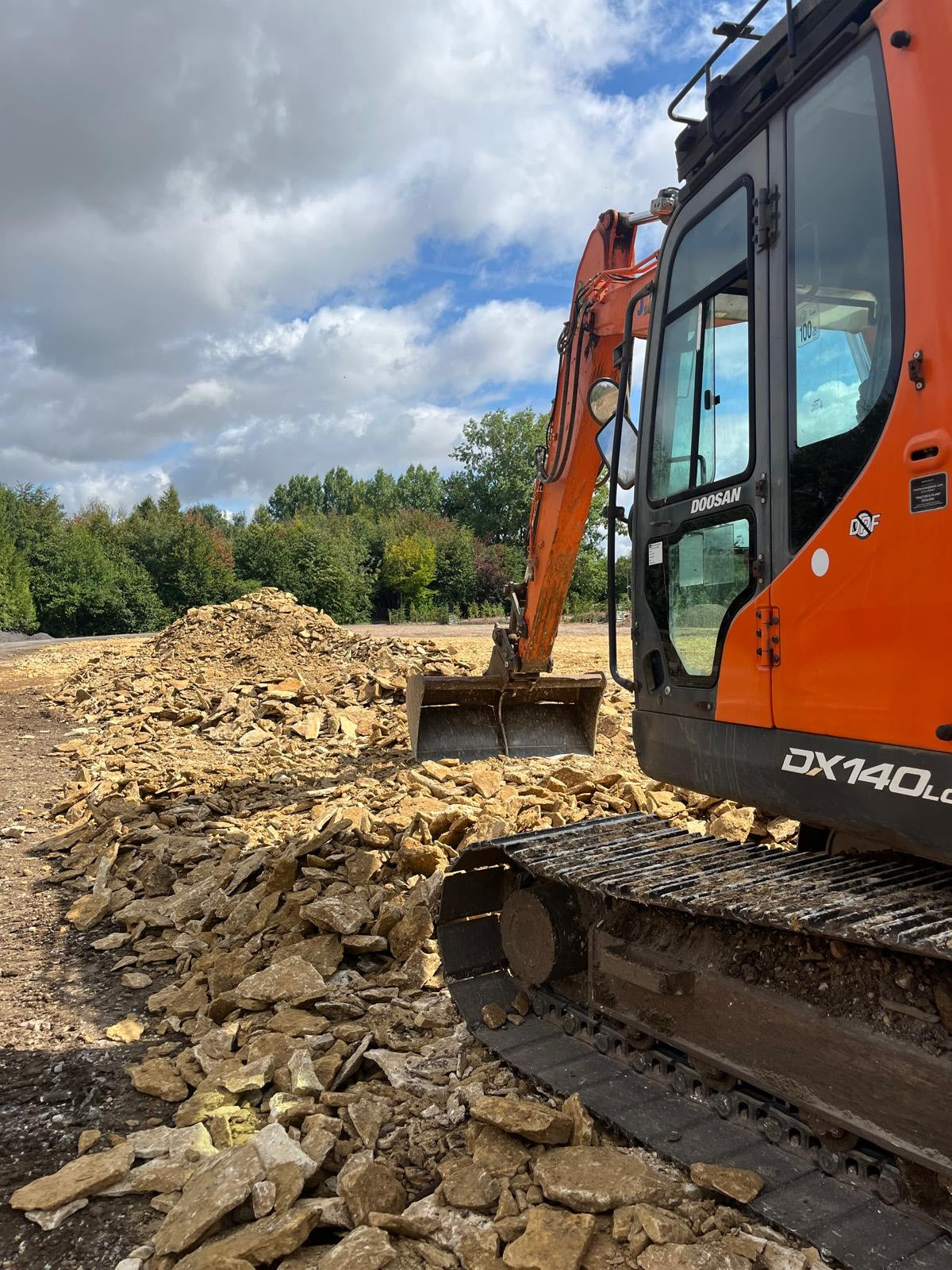 6.5 tonne excavator scraping up stone from a field in Watlington.
