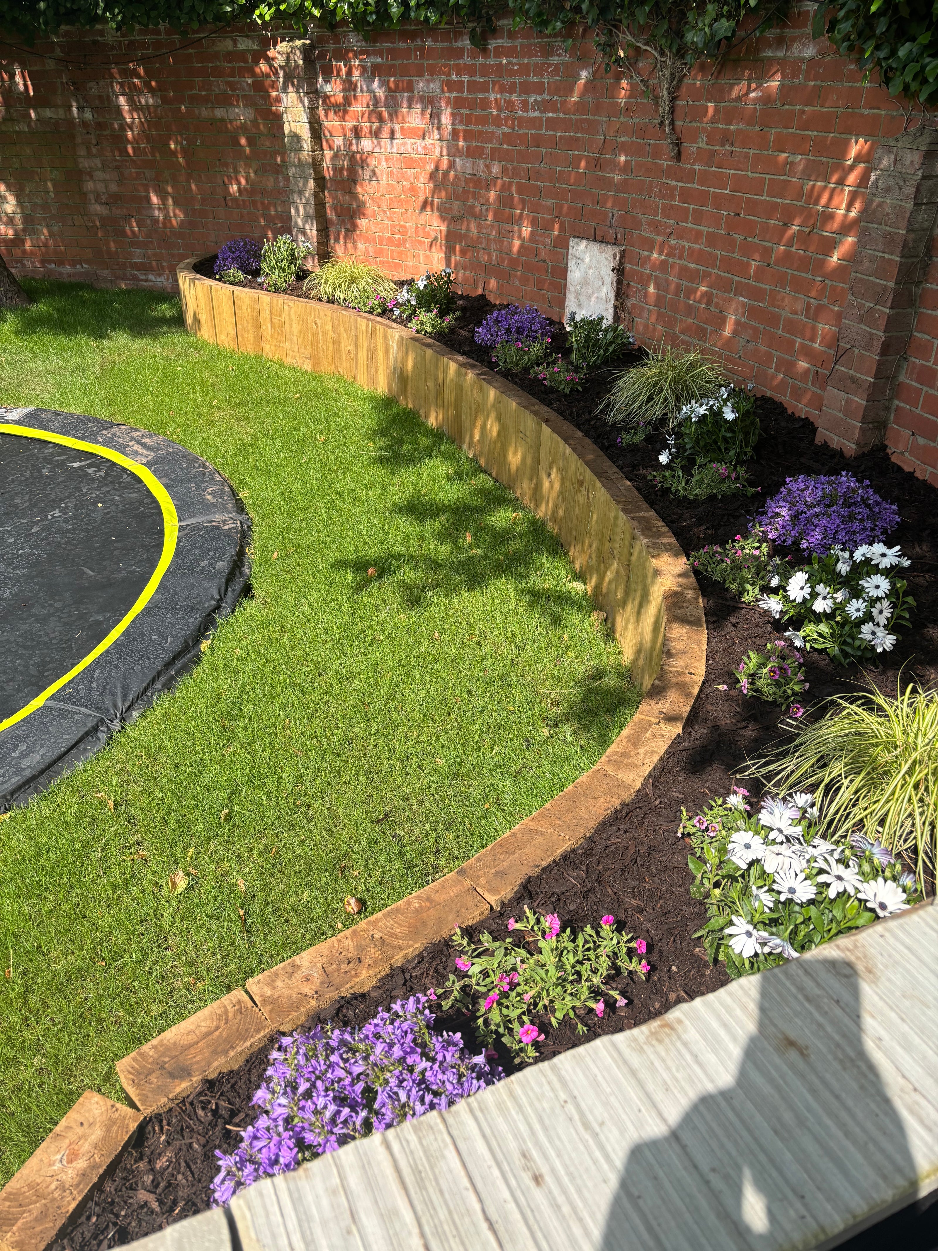 New turf laid in Binfield-Heath along with inground trampoline and flower beds.