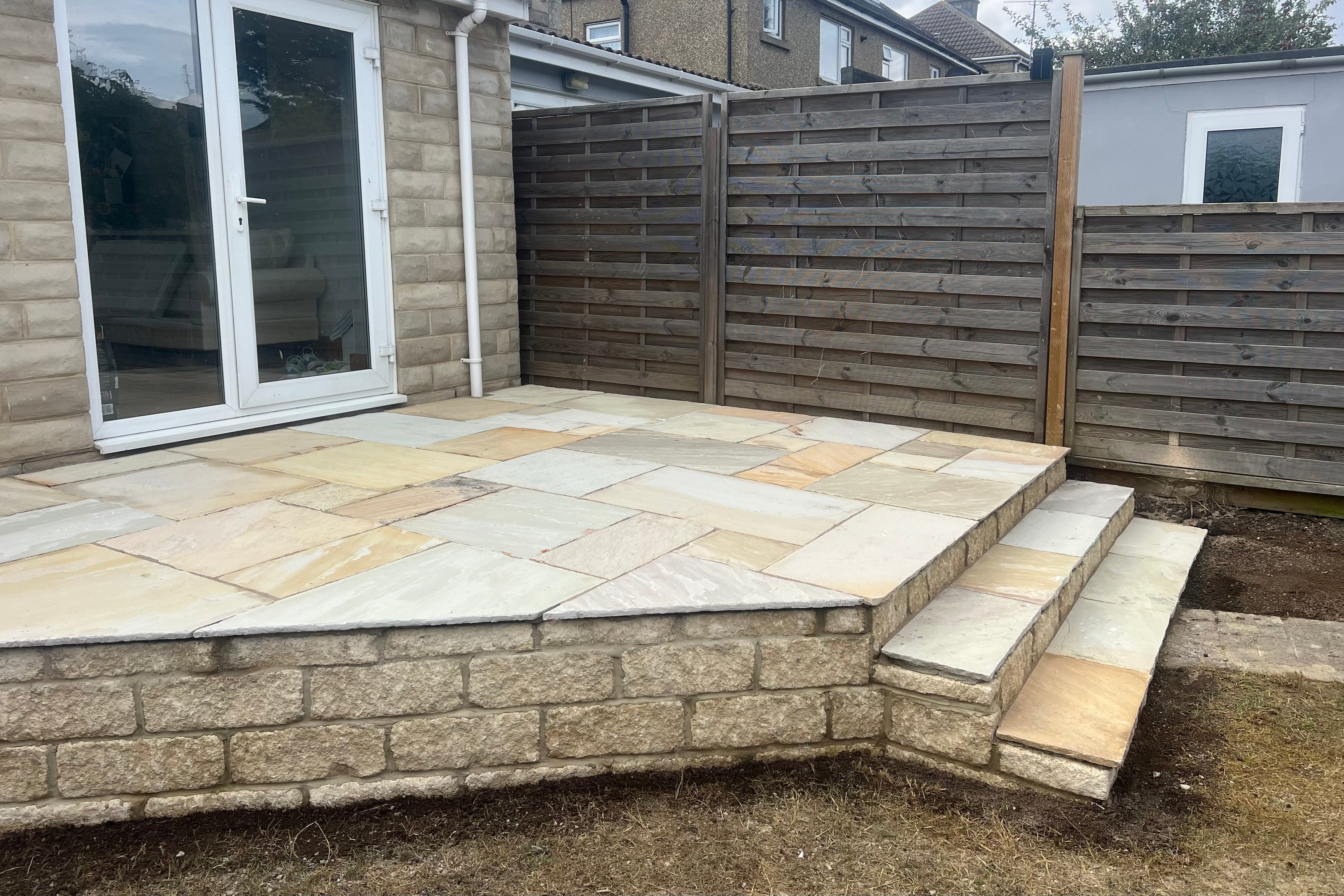 Raised patio in Henley-on-Thames with steps and retaining wall. 