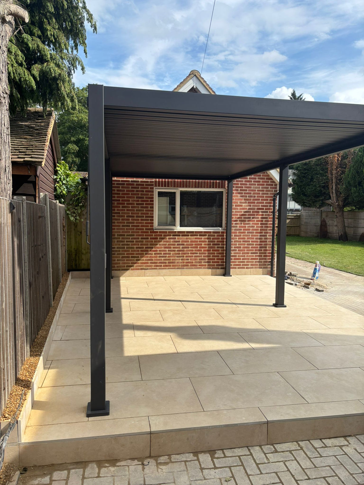 Porcelain patio area with custom Pergola build to offer shade in Shiplake, Henley-On-Thames.
