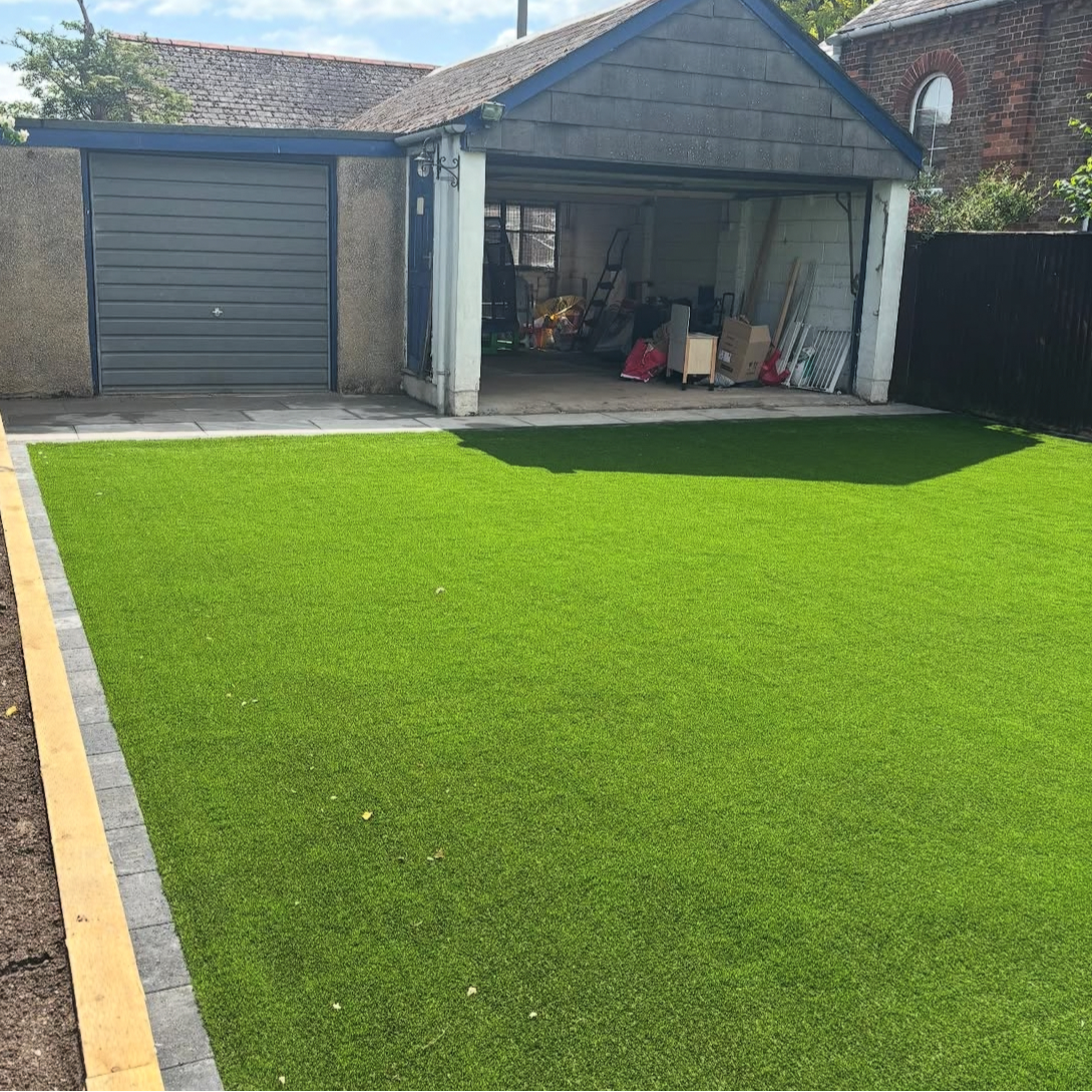 Artificial turf installed in Chinnor with block paving edgers and a flower bed.