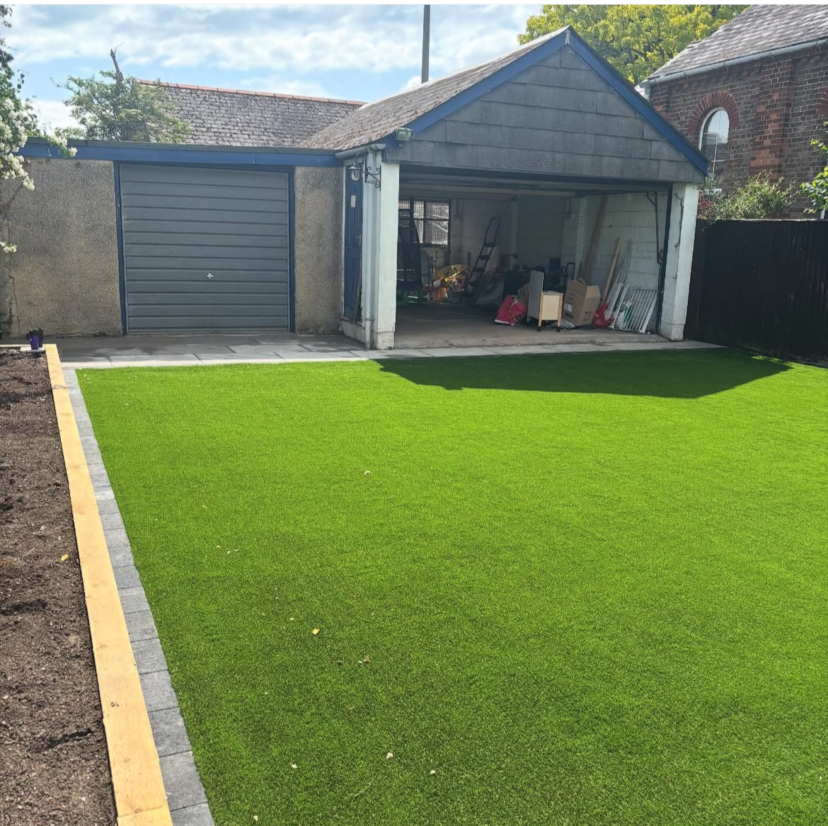 Artificial turf installed in Chinnor with block paving edgers and a flower bed.