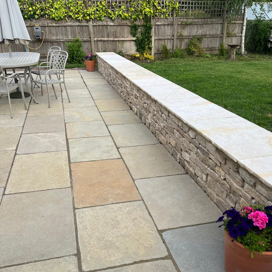 Paved patio area on garden renovation in Henley-On-Thames, with patio, low wall and grass.