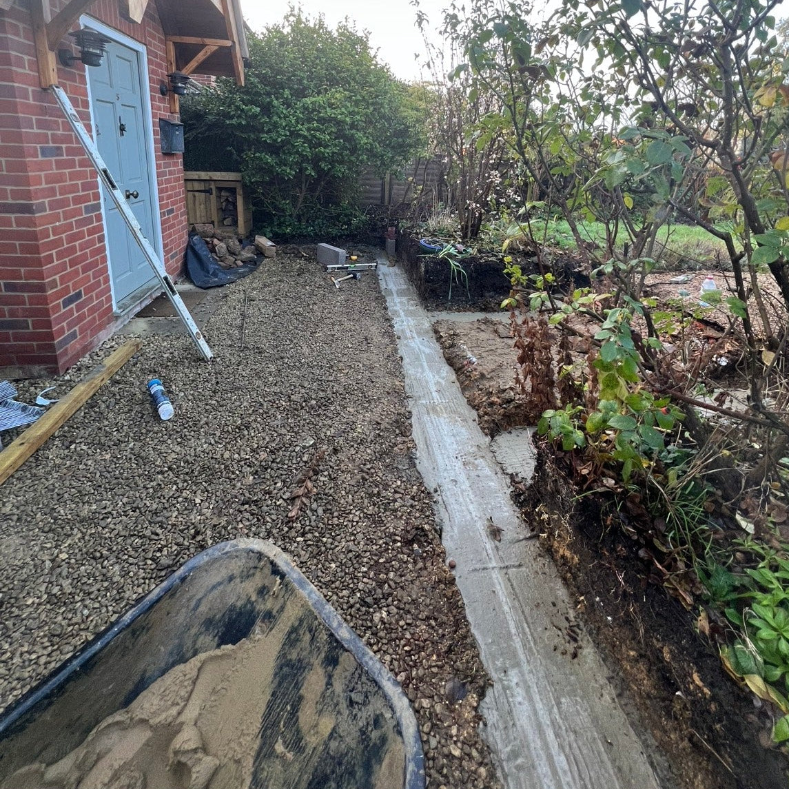 Backyard with gravel pathway and garden area, showing construction or landscaping work.
