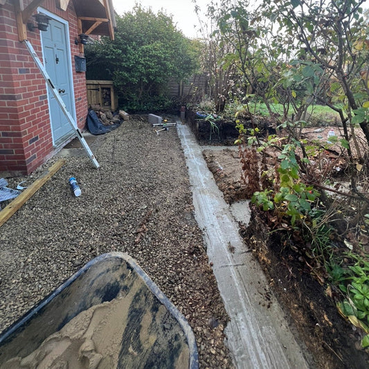 Backyard with gravel pathway and garden area, showing construction or landscaping work.