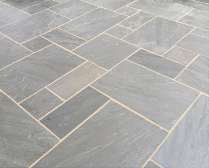 Patterned stone pavement with a natural stone border