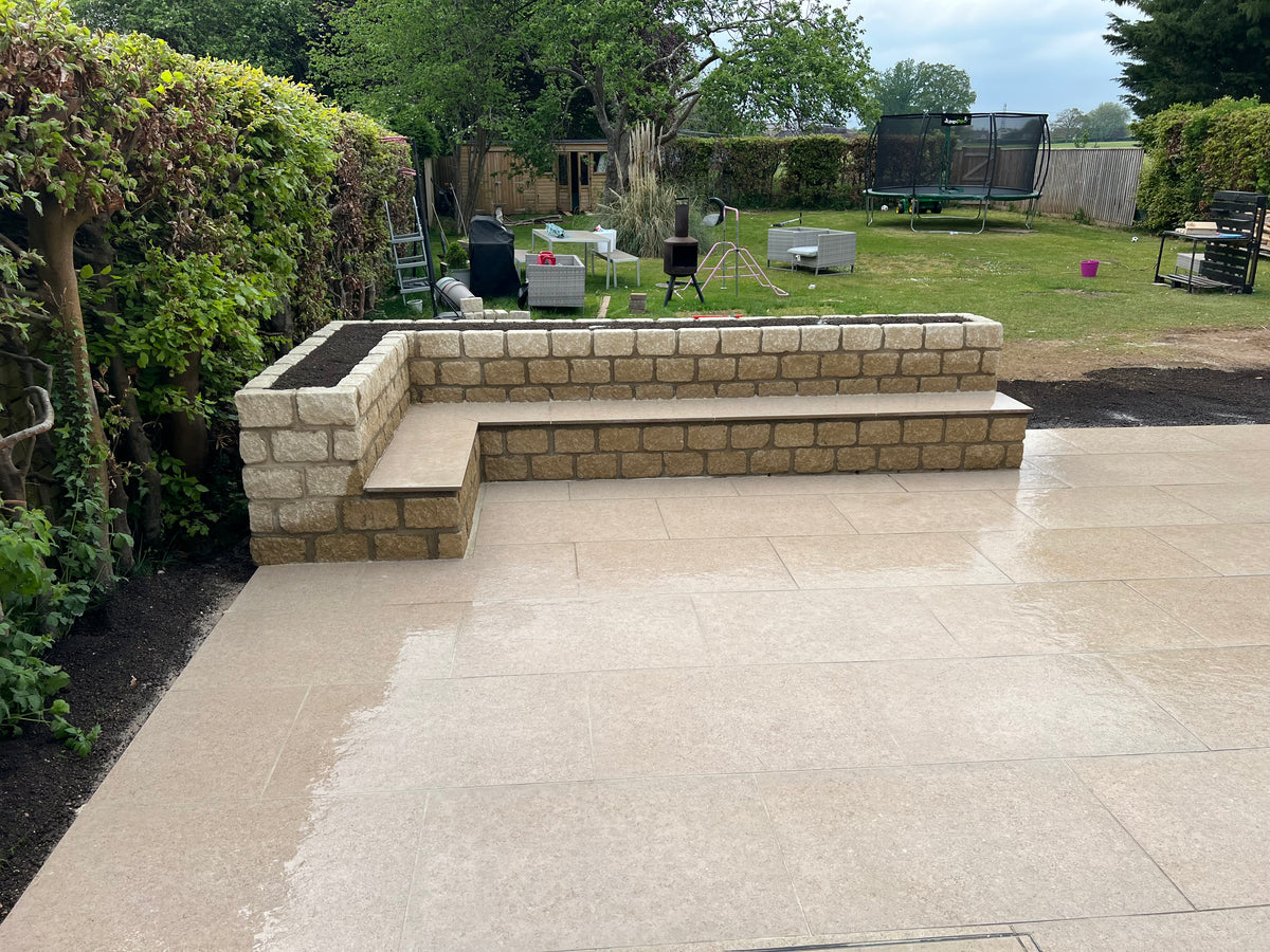 A garden seat made out of natural stone incorporating a planter bed within it at a property in Henley-On-Thames. 