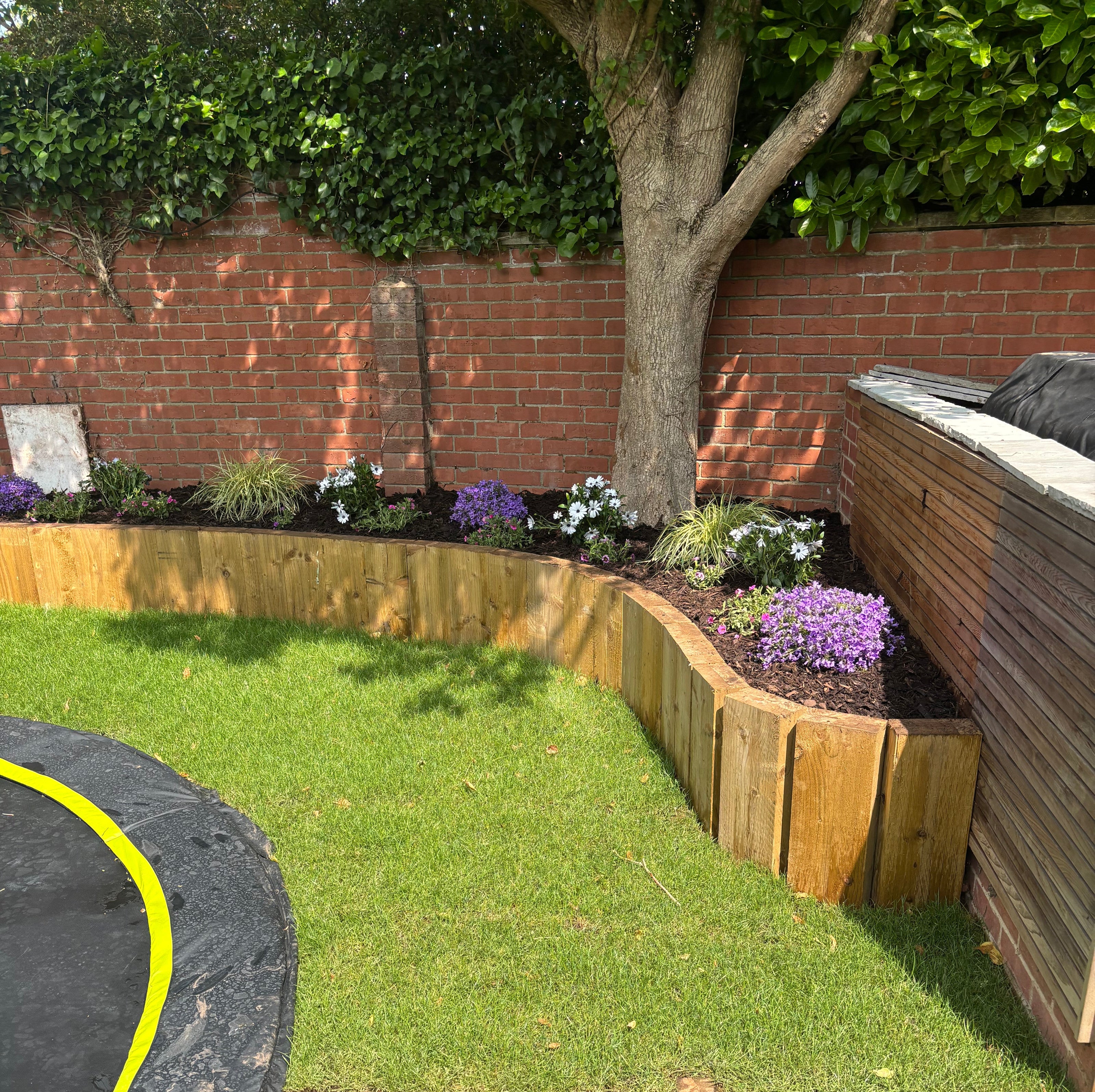 Binfield Heath garden with raised sleeper bed, new turf and planted flowers.
